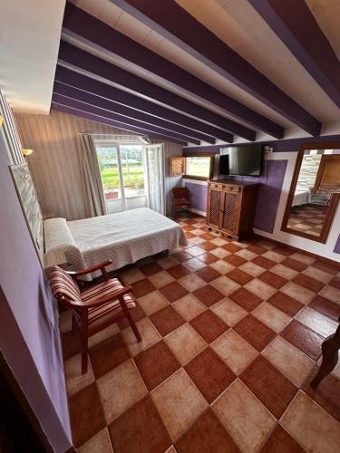 a bedroom with a bed and a checkerboard floor at Hosteria,restaurante,cafeteria Los Abetos in Villanueva de la Peña