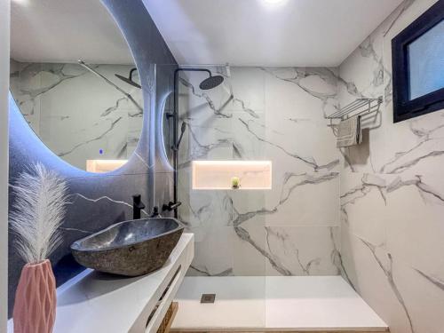ein Badezimmer mit Waschbecken und Spiegel in der Unterkunft El Bunker Luxury Suite en Playa del Hombre con vista al mar in Playa del Hombre