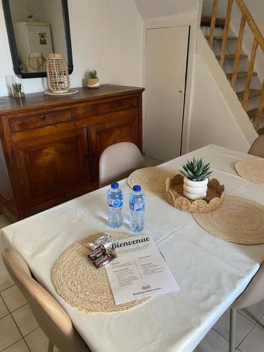 a table with two bottles of water on it at Maison cosy avec cour privée - Calme et nature, La Trimouille in La Trimouille