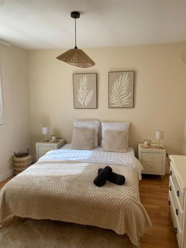 a bedroom with a bed with a hat on it at Maison cosy avec cour privée - Calme et nature, La Trimouille in La Trimouille
