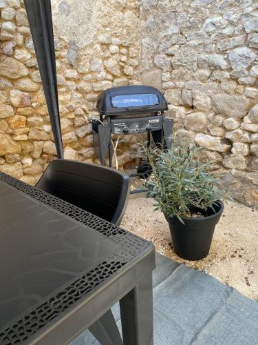 a grill sitting next to a table and a chair at Maison cosy avec cour privée - Calme et nature, La Trimouille in La Trimouille