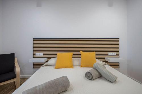 ein Schlafzimmer mit einem großen Bett mit gelben Kissen in der Unterkunft El Bunker Luxury Suite en Playa del Hombre con vista al mar in Playa del Hombre