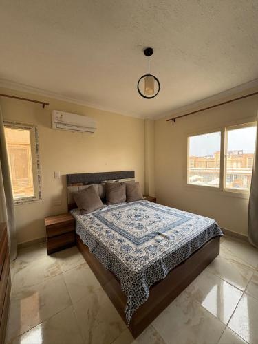 a bedroom with a bed with a blue and white comforter at Coronado Dabaa Beach in Zāwiyat ‘Abd al Mun‘im