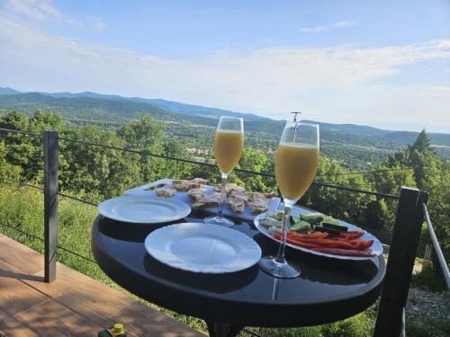 a table with two glasses of wine and food at Csudahely - WonderPlace in Dunabogdány