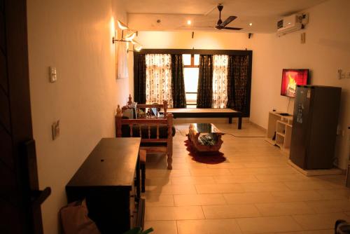 a living room with a table and a kitchen at The Bird House in Ukunda Airport