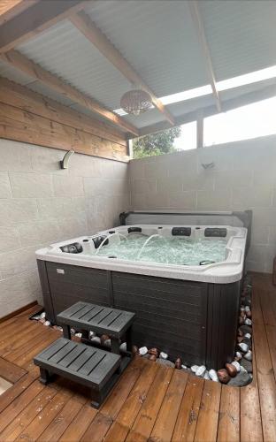 a hot tub in a room with a wooden floor at ATÈRLA - Appartement de charme et spa in La Possession