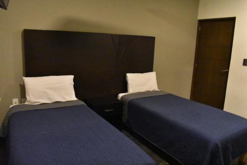 two beds sitting next to each other in a room at Hotel Casa 20 in León