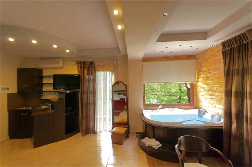 a bathroom with a large tub in a room at Nostos Hotel in Kato Loutraki