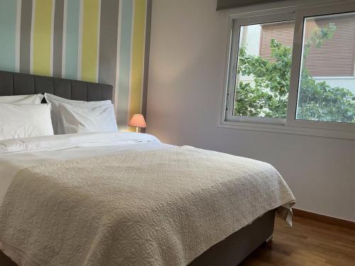 a bedroom with a bed and a window at 2BDRM Glyfada Residence - Jacuzzi, Garden & Parking in Athens