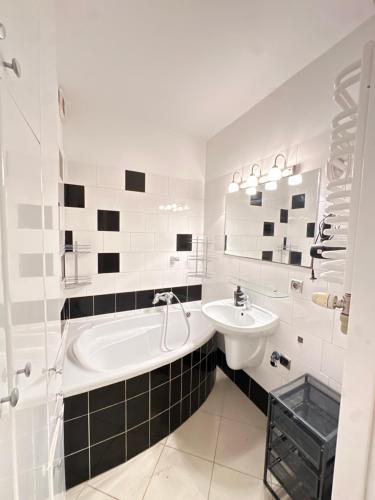 a white bathroom with a tub and a sink at Palace of Culture Skyline in Warsaw