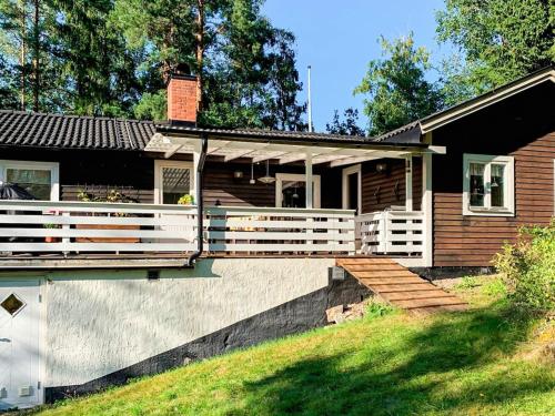 a house with a porch and white railing at 8 person holiday home in Ärla in Malmköping