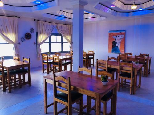 a dining room with wooden tables and chairs at Hotel Marwa in Tan-Tan Plage