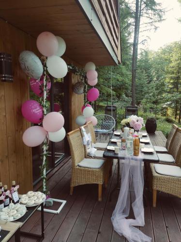 a table on a deck with pink and white balloons at Chatki Bernadki - Siedliska na Roztoczu in Siedliska