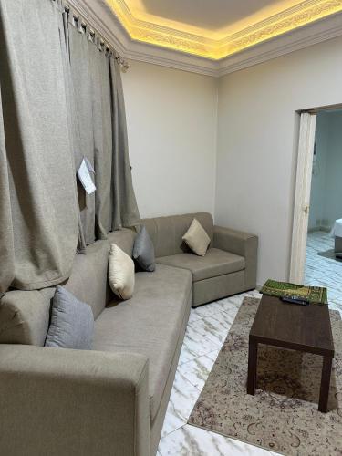a living room with a couch and a coffee table at أجنحة السلام للشقق المفروشة in Al Madinah