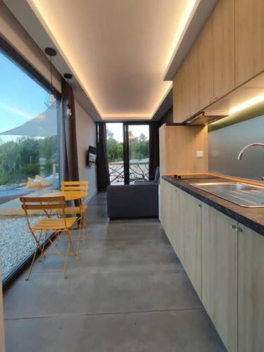 a kitchen with a sink and a table and chairs at PoucoPico in Sesimbra