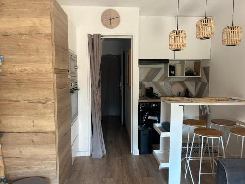 a kitchen with a counter and some stools in a room at Studio le Mistral in Saint-Raphaël