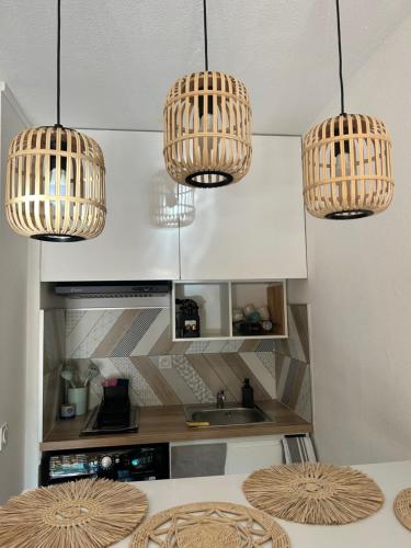 a kitchen with three lights hanging from the ceiling at Studio le Mistral in Saint-Raphaël