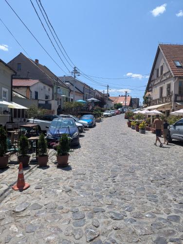 a cobblestone street with cars parked in a town at House in Gardos in Zemun