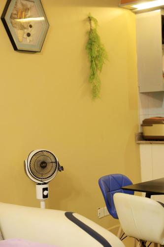 a room with a fan and a table and chairs at AG Home - Kampala in Kampala