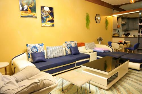 a living room with a blue couch and chairs at AG Home - Kampala in Kampala