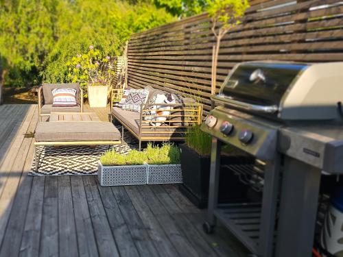a outdoor patio with a grill and a couch at Privat Spirit Spa Villa in Vallentuna