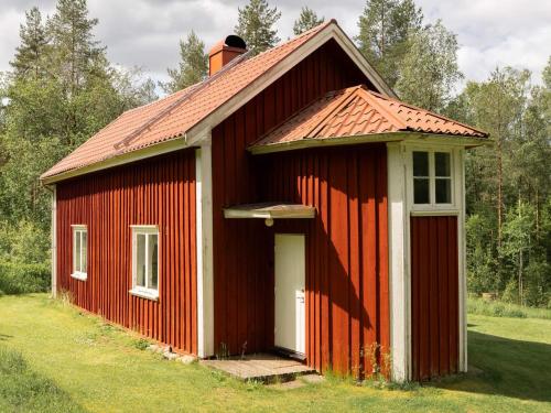 a red barn with a white door in a field at 6 person holiday home in SANDHULT-By Traum in Sandhult