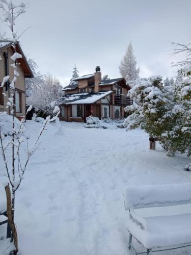 a yard covered in snow next to a house at Cabañas Las Lumas Esquel in Esquel