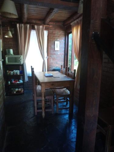a dining room with a wooden table and chairs at Cabañas Las Lumas Esquel in Esquel