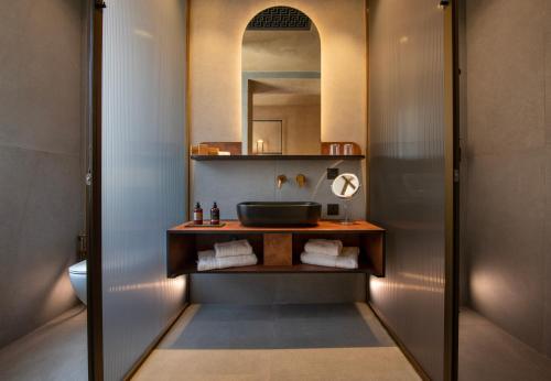 a bathroom with a sink and a mirror at Nearchou Boutique Hotel in Chania Town