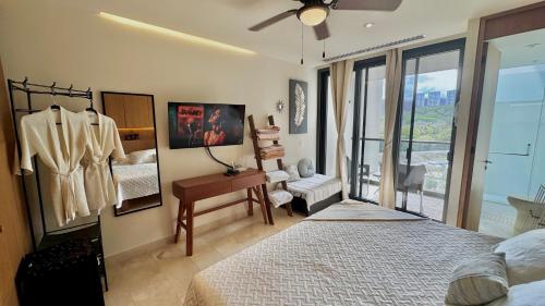a bedroom with a bed and a desk and a window at Beachfront Studio at Zantamar in Cruz de Huanacaxtle
