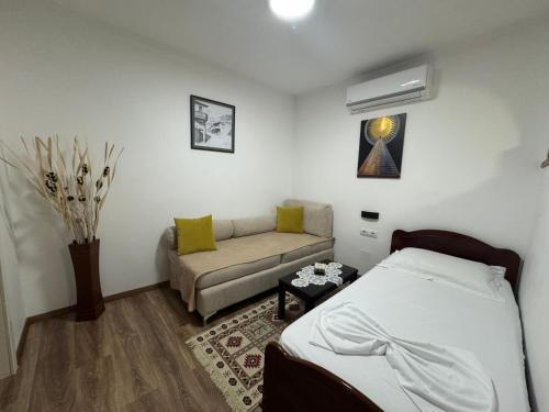 a bedroom with a bed and a couch at Double17 Apartaments in Gjirokastër