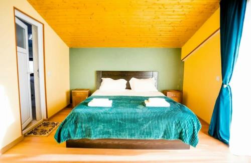 a bedroom with a bed with a green comforter at Sunny Hill Gudauri in Gudauri