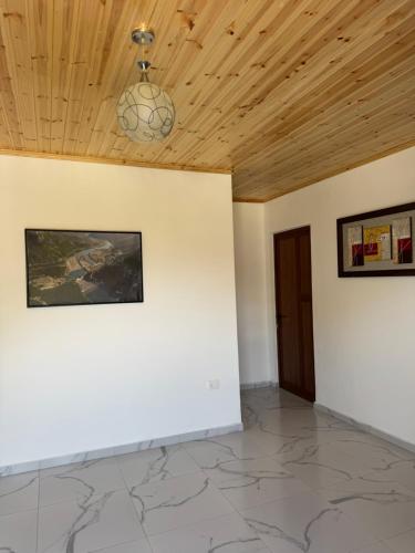 a room with white walls and a wooden ceiling at Xhoen Haven in Shkodër