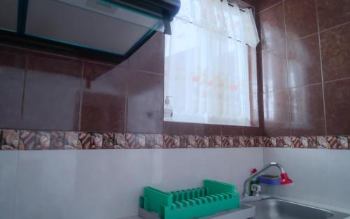 Un baño con lavabo y una ventana con cestas verdes. en Departamentos "GARCÍA LÓPEZ" es amplio muy acogedor 2 dormitorios y cerca del Auditorio Guelaguetza, en Oaxaca City