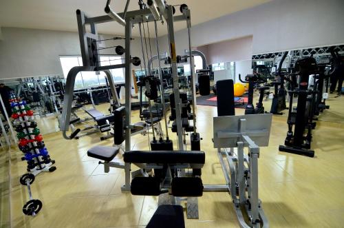 une salle de sport avec plusieurs tapis de course et machines dans l'établissement Hotel Capital da Fe, à Aparecida