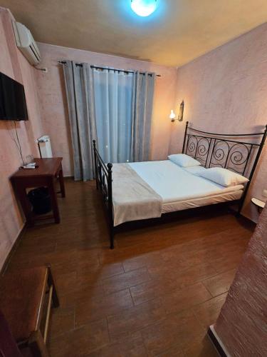 a bedroom with a large bed and a table at Boutique Hotel Colosseo in Sandanski