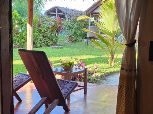 a patio with two chairs and a table with a plant at KINTANA LODGE in Ile aux Nattes