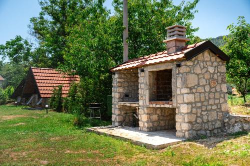a stone fireplace in a yard with a house at NAJ village in Cetinje