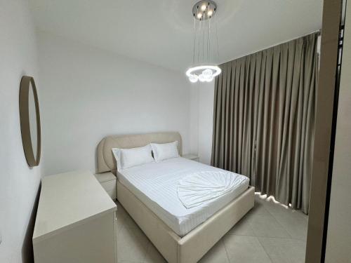 a small bedroom with a bed and a window at Rana E Hedhun Apartment in Lezhë
