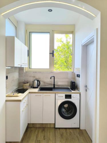 a kitchen with a washing machine and a window at New Apartment close to Sea and Downtown in Vlorë