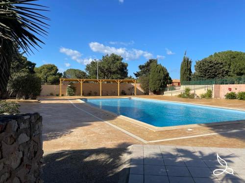 une piscine au milieu d'une cour dans l'établissement Maison - piscine - clim - wifi - vue lac - 4 pers, à Fitou