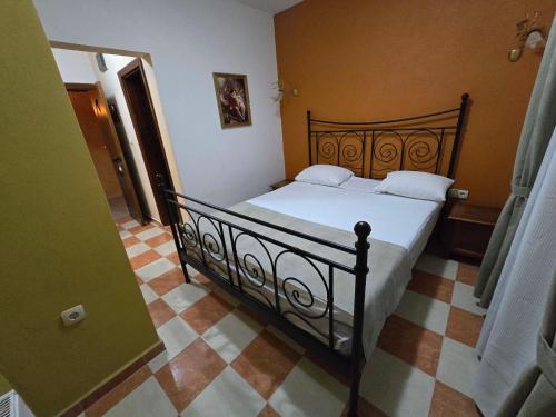 a bedroom with a black bed with white pillows at Boutique Hotel Colosseo in Sandanski