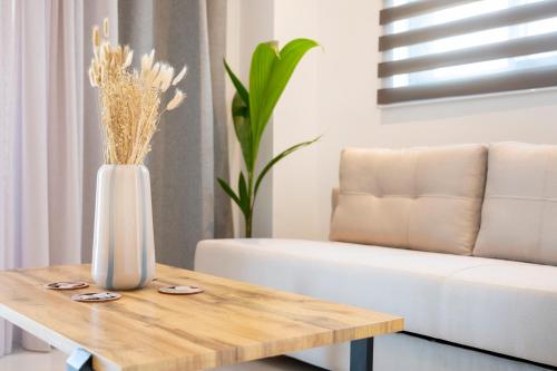 a vase on a coffee table in front of a couch at Unicos City Suites in Kos Town