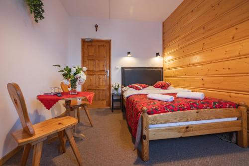 a bedroom with a bed and a wooden wall at Pokoje Gościnne Góraleczka in Szaflary