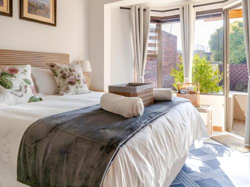 a bedroom with a large bed with a large window at Amalfi Place in Pretoria