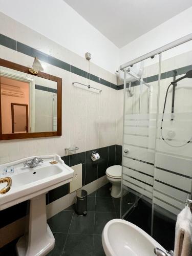 a bathroom with a sink and a shower and a toilet at Villa Edelweiss in Bacoli