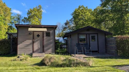 a small shed with a door in the grass at Boats stay play lake cabin in Broby