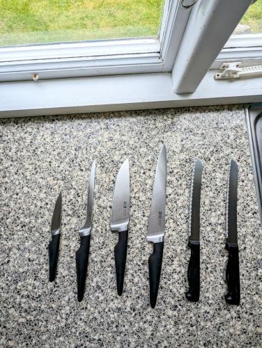 a group of knives lined up next to a window at Boats stay play lake cabin in Broby