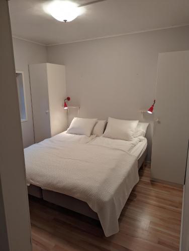 a bedroom with a large bed with white sheets at Boats stay play lake cabin in Broby