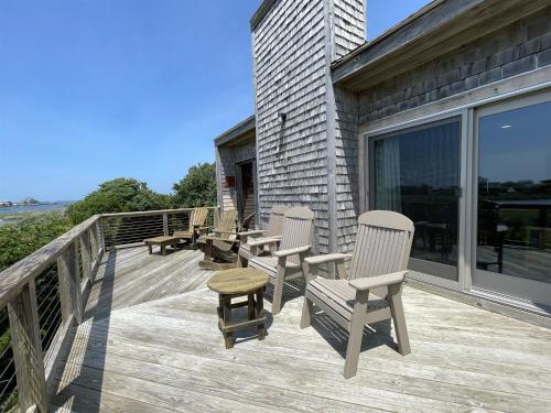 a deck with three chairs and a stool on it at Elizabeth House 56126 in Hatteras